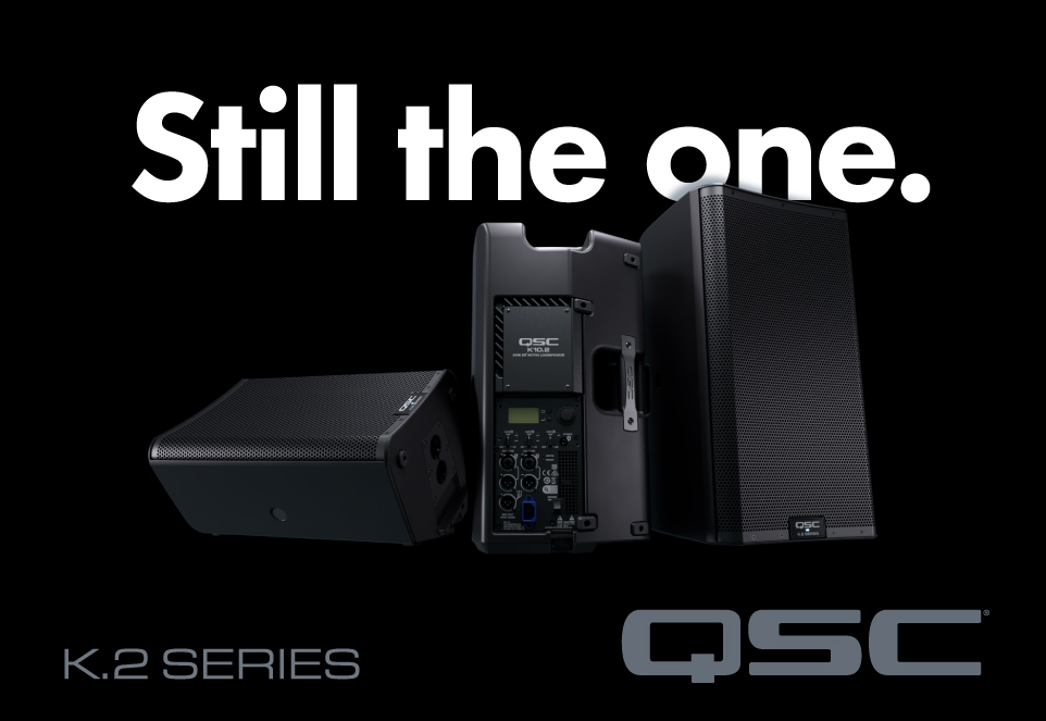 Werbebanner für QSC K.2 Series Lautsprecher mit mehreren Boxen in Schwarz und dem Slogan ‚Still the one‘.