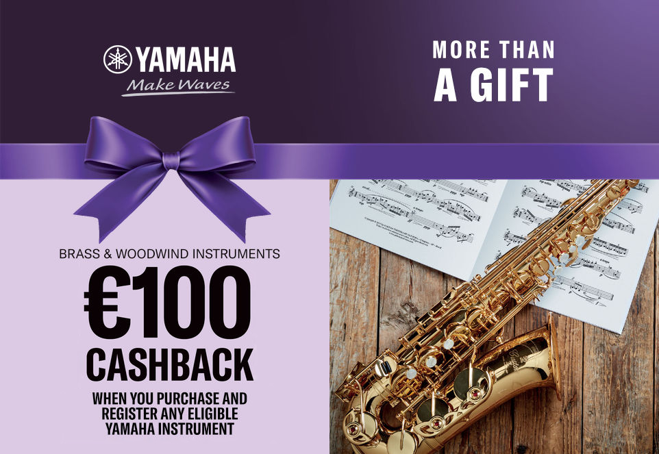 Yamaha banner featuring a golden saxophone on a wooden table with sheet music and a purple ribbon, text: €100 cashback on selected Yamaha brass and woodwind instruments.