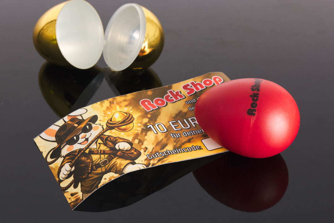 Geöffnetes goldenes Ei mit 10 Euro Einkaufsgutschein und rotem Rock Shop Egg-Shaker